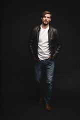 Fashion man, Handsome serious beauty male model portrait wear leather jacket, young guy over black background