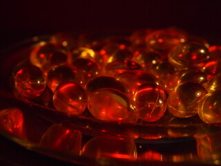 Trans-lucid cod liver oil pills under colourful light