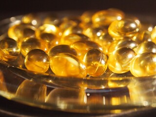 Trans-lucid cod liver oil pills under colourful light