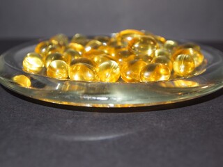 Trans-lucid cod liver oil pills under colourful light