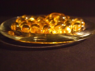 Trans-lucid cod liver oil pills under colourful light
