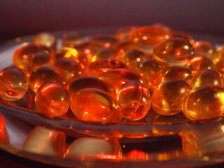 Trans-lucid cod liver oil pills under colourful light