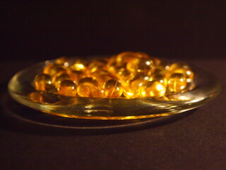 Trans-lucid cod liver oil pills under colourful light