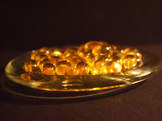 Trans-lucid cod liver oil pills under colourful light