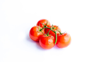 On a white background. No isolation. Red tomato on a green branch. There is a shadow.
