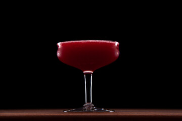 Red cherry gin cocktail, deep red color on black background
