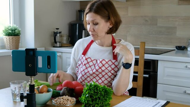 Food blogger woman talking about healthy food in front of the web camera smart phone, food vlog
