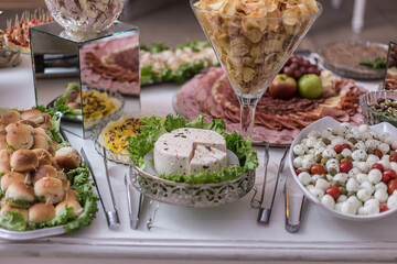 Vários alimentos em vasilhas distribuidos sobre mesa de buffet.