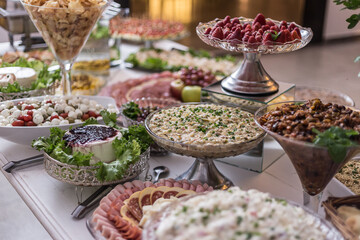 Vários alimentos em vasilhas arranjados sobre uma mesa de buffet.