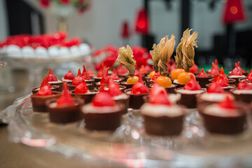 Punhados de chocolate com pimenta e physalis em vasilha sobre a mesa de buffet.