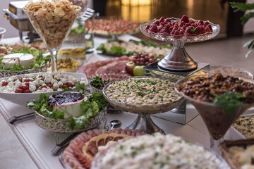 Vários vasilhas com alimentos diversos sobre mesa de buffet.