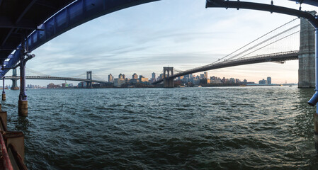 panoramic view of bridges and water in a city after sunset