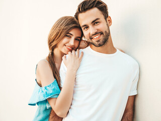 Naklejka premium Portrait of smiling beautiful woman and her handsome boyfriend. Woman in casual summer jeans dress. Happy cheerful family. Female having fun. Couple posing on the street background in sunglasses
