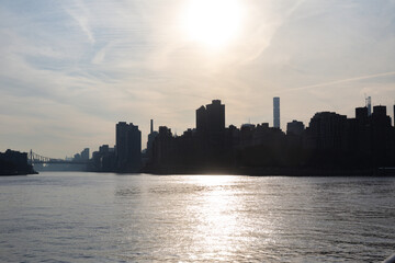 shadow of a city on the side of the water in summer on a nice sunset with tall buildings