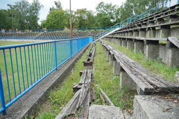 Decayed wooden banks in tribune or auditorium of a devastated football stadium in a provincial town in Eastern Europe.
