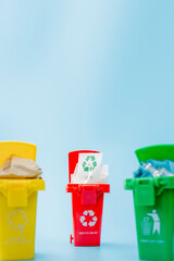 Yellow, green and red recycle bins with recycle symbol on blue background. Keep city tidy, Leaves the recycling symbol. Nature protection concept