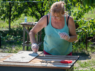 Installation of ceramic tiles on a garden wooden table