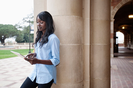 African American student using digital tablet outdoors