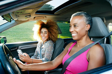 Mother and daughter driving car