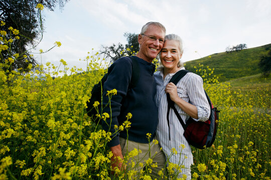 Caucasian couple standing in tall grass - Powered by Adobe