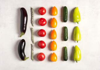 Fresh vegetables, eggplants, beans, tomatoes, cucumbers, peppers lie on a gray background, flat lay, knolling, pattern, top view. Vegetarian diet food concept.