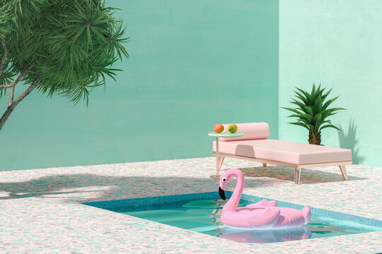 Pink toy flamingo floating on swimmingpool next to sunbed and palm trees