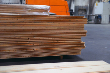 Timber Flooring Factory. Pile of cut wood in factory storage warehouse. Lumber in warehouse.