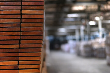 Timber Flooring Factory. Pile of cut wood in factory storage warehouse. Lumber in warehouse.