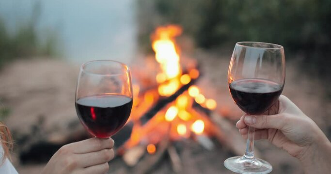 to clink glasses on the background of the campfire