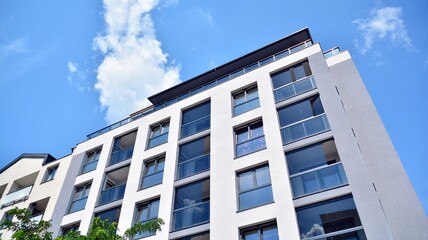 Fototapeta premium Modern apartment buildings on a sunny day with a blue sky. Facade of a modern apartment building. Glass surface with sunlight.
