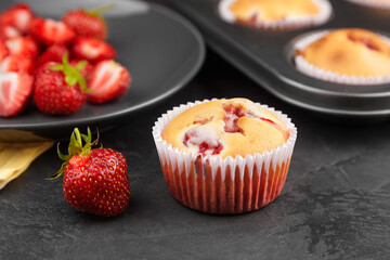 Homemade strawberries muffin with fresh strawberries on dark concrete background