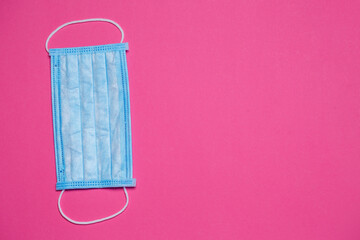 Fototapeta na wymiar Blue medical surgical mask for protection against the virus on a colored background