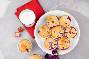 Strawberry muffin dessert with fresh milk glass on gray background