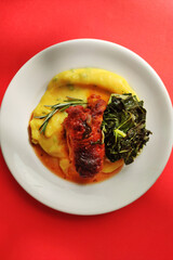 roasted chicken and creamy polenta and red background