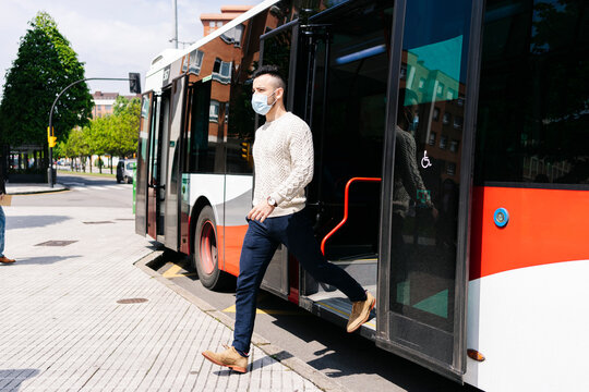 Young Man Wearing Protective Mask Getting Off Public Bus, Spain