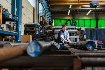 Man working with metal bars in a factory