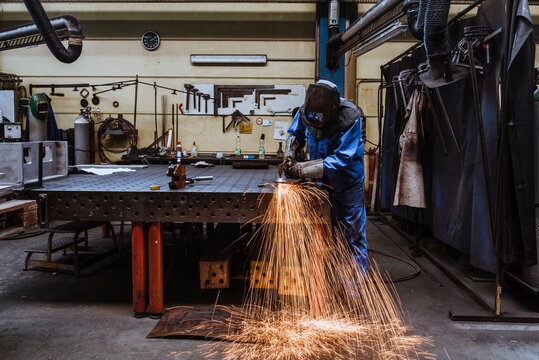 Welder welding metal in a factory