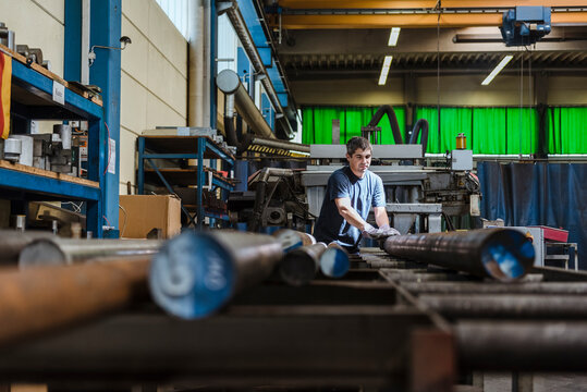 Man working with metal bars in a factory