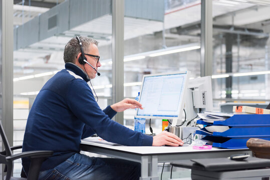 Man with headset sitting at desk in office