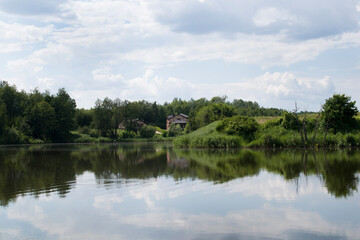 Fototapeta na wymiar Landscape background with houses near a forest lake. 