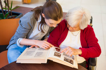 Grandmother with granddaughter looking photo album at home