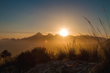 Beautiful sunset in a valley beyond the mountains.