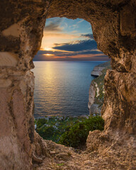 Fototapeta na wymiar Sunset over Dingli Cliffs through the natural arch formation in the cliffs