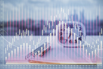 Multi exposure of financial graph drawings and desk with open notebook background. Concept of forex