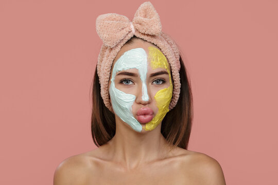 Woman Cleansing Facial Mask. Clay Of Blue-yellow Cream Covers Part Of The Face. Home Headband. Blow A Kiss