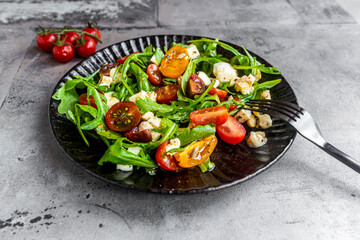 Plate of lowÔøΩcarbÔøΩvegetarian salad with arugula, tomatoes, nuts and Mozzarella cheese