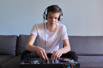 Creative teen boy in headphones with mixer equipment entertainment dj station