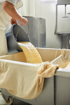 Cheese factory, female worker sieving whey