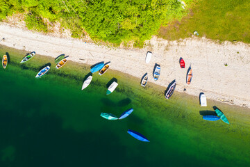 Germany, Bavaria, Lenggries,R owboats left on green shore of Sylvenstein Reservoir