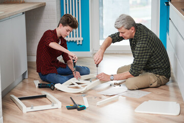 father and son work together. kitchen chair assembling